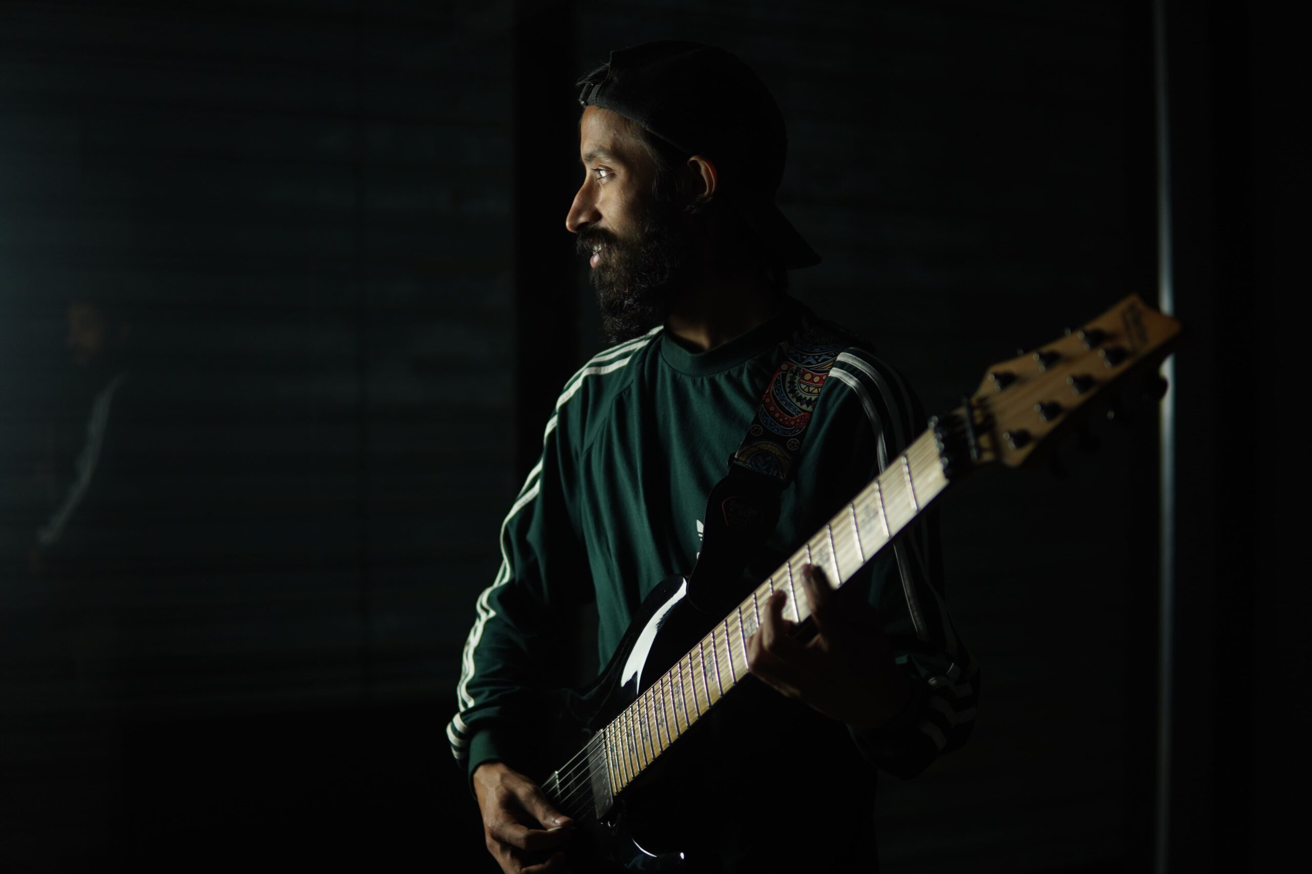 Rahul Bhattacharjee playing electric guitar in the background to highlight his music on Spotify and Bandcamp.